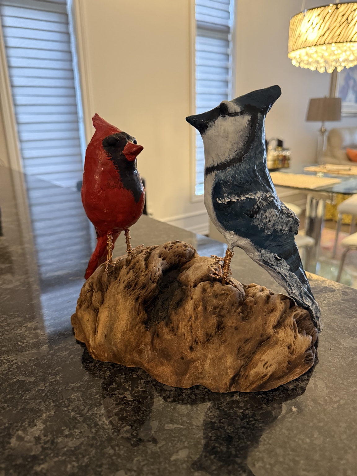 Handcrafted cardinal and blue jay on driftwood